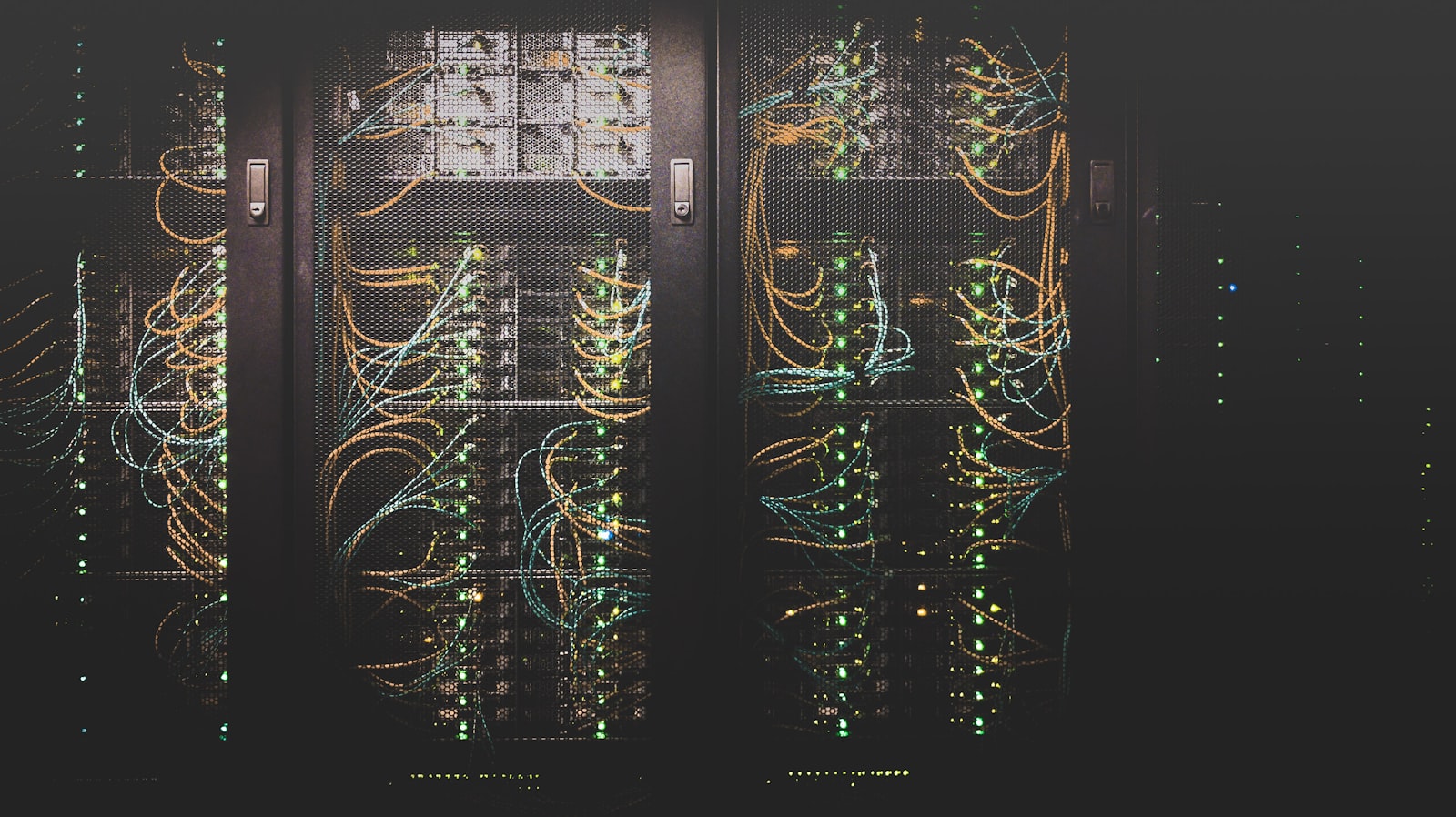 Server racks with dense network cabling glowing in a dark data center